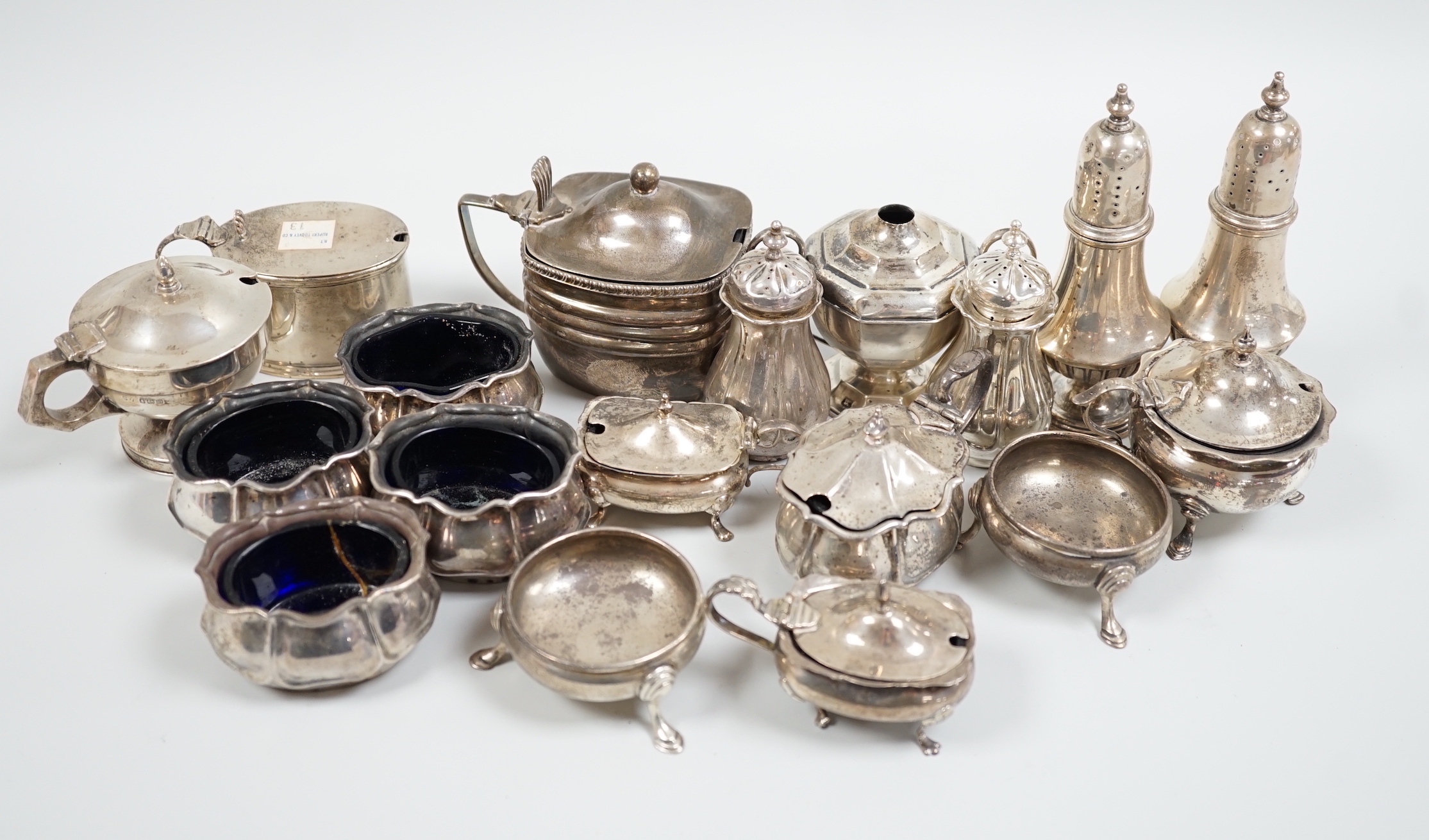 An Edwardian seven piece silver condiment set, Atkin Bros. Sheffield, 1903/4 and eleven other silver condiments including a pair of pepperettes.